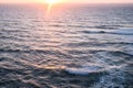 Aerial view over the ocean of sun rising over waves surface Royalty Free Stock Photo