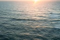 Aerial view over the ocean and sun rising over water waves surface Royalty Free Stock Photo