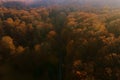 Aerial view over road going through autumn forest with red leave Royalty Free Stock Photo