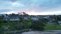 Aerial view over the shore and rooves of seaside houses at Murrays bay, Auckland, during the sunset