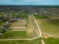 Aerial view over a small village near a dirt road. Large multi-colored fields planted with various agricultural crops. Wheat field Royalty Free Stock Photo