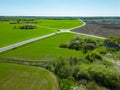 Aerial view over a small village near a dirt road. Large multi-colored fields planted with various agricultural crops. Wheat field Royalty Free Stock Photo