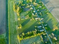 Aerial view over a small village near a dirt road. Large multi-colored fields planted with various agricultural crops. Wheat field Royalty Free Stock Photo