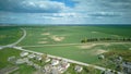 Aerial view over a small village near a dirt road. Large multi-colored fields planted with various agricultural crops. Wheat field Royalty Free Stock Photo