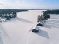 Aerial view over snowy lake and winter forest