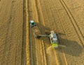 Aerial view over the top of a combine harvester and tractor. Harvest machine loading freshly harvested cereal into tracktor for tr
