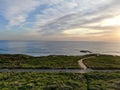 Aerial view of Pacific ocean colorful sunset with sun reflection on the ocean and deep clouded sky. Royalty Free Stock Photo