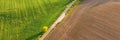 Aerial view. Panorama. Agricultural path divides the green and brown field