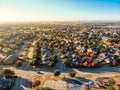 Aerial view park side residential houses with urban sprawl background in fall morning Royalty Free Stock Photo