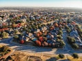 Aerial view park side residential houses with urban sprawl background in fall morning Royalty Free Stock Photo