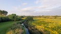 Aerial view of a park with yellow flowers with a river running through it. Royalty Free Stock Photo