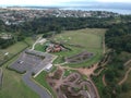 Aerial view of a parking lot near a baseball field, enclosed by lush trees