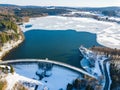Aerial view of the partially frozen Brucher dam near Marienheide in winter.