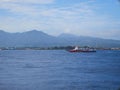 Aerial view passenger ferry floating in sea in background og mountains in Bali