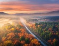 Aerial view of passenger train in autumn forest in fog at sunset Royalty Free Stock Photo