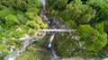 Aerial view of a pedestrian bridge through a gorge with a waterfall, top view Royalty Free Stock Photo