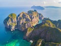 Aerial view of Phi Phi, Maya beach with blue turquoise seawater, mountain hills, and tropical green forest trees at sunset with