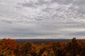 an autumn view from a hill top, with clouds and leaves in the foreground