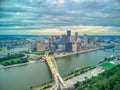 Aerial view of Pittsburgh downtown skyline with bridges on under dramatic sky