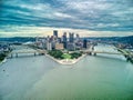 Aerial view of Pittsburgh downtown skyline with bridges on under dramatic sky