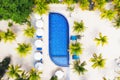 Aerial view at the pool and palm trees. A place for rest and relaxation. Beach umbrellas. Beach club for relaxation in Asia. Bali