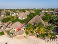 Aerial view of pool, umbrellas, sandy beach with green Palm trees. Coast of Indian ocean at sunset in summer. Zanzibar Royalty Free Stock Photo