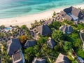 Aerial view of pool, umbrellas, sandy beach with green Palm trees. Coast of Indian ocean at sunset in summer. Zanzibar Royalty Free Stock Photo