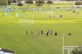 Aerial view of public sports park with children engaged in football game on grass stadium at sunset. Active way of life Royalty Free Stock Photo