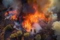 aerial view of raging wildfire, with firefighters in full gear battling the flames