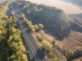 Aerial view railroad in autumn forest in foggy sunrise. Top view rural railway