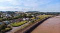 An aerial view of a railway track dam along a sandy beach, road and building area under a majestic cloudy blue sky Royalty Free Stock Photo