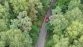 Aerial aerial view of a red car driving on country road at day. Royalty Free Stock Photo