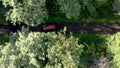 Aerial view of red car driving on country road in forest Royalty Free Stock Photo