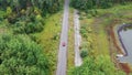 Aerial view of red car driving on country road in forest. Royalty Free Stock Photo