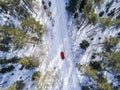 Aerial view of a red car on white winter road. Winter landscape countryside. Aerial photography of snowy forest with a car on the Royalty Free Stock Photo