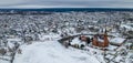 Aerial view of red catholic church and small town in winter. Idyllic landscape with church, houses, river and riverbank Royalty Free Stock Photo