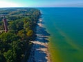 Aerial view at red lighthouse, at baltic sea coast with forest and buildings.