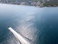 Aerial view of a red motor boat speeds by in the Kotor fjord in Montenegro.