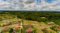 Aerial view of rice terrace filled water, mirroring sky clouds and palm trees.