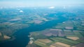 Aerial view of river and plantation fields. Green field and river under the clouds