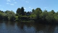 Aerial view of a river in summer village and an old wooden house. Shot. Forest and small house surrounded by green trees Royalty Free Stock Photo