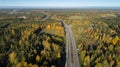 Aerial view of road in beautiful autumn forest. Beautiful landscape with asphalt rural road, trees with red and orange leaves. Royalty Free Stock Photo