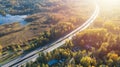 Aerial view of road in beautiful autumn forest. Beautiful landscape with asphalt rural road, trees with red and orange leaves. Royalty Free Stock Photo