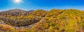 Aerial view of road in beautiful autumn forest at sunset. Beautiful landscape with empty rural road, trees with red and Royalty Free Stock Photo