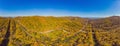 Aerial view of road in beautiful autumn forest at sunset. Beautiful landscape with empty rural road, trees with red and Royalty Free Stock Photo