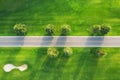 Aerial view of road through beautiful green field at sunset Royalty Free Stock Photo