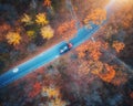 Aerial view of road with blurred car in autumn forest at sunset Royalty Free Stock Photo