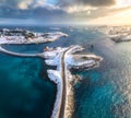 Aerial view of road, bridges, snowy islands, rorbu, sea at sunset