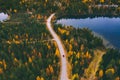 Aerial view of road with car through fall woods with green and yellow trees in Finland Royalty Free Stock Photo