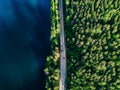 Aerial view of road with cars between green forest and blue lake in Finland Royalty Free Stock Photo